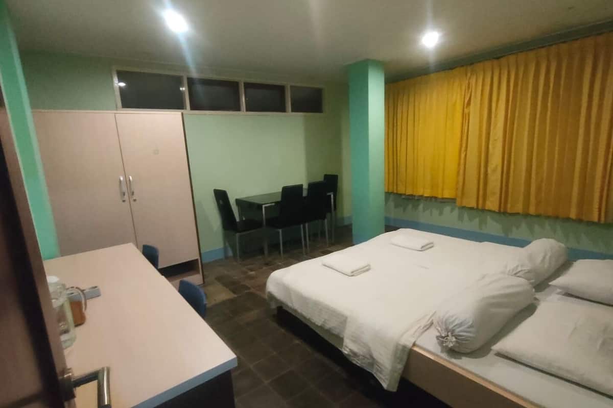 Ein Hotelzimmer mit Bett, Schreibtisch, Stuhl und einem kleinen Tisch.