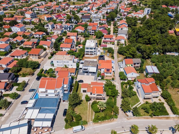 An aerial view of a residential area with houses, roads, and greenery.