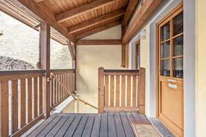 Um deck de madeira com guarda-corpo, escadas e uma porta com uma placa.