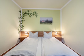 A double bed with two bedside tables, a wall-mounted picture, and a plant. - Room 'Doppelzimmer 1' with Shared Terrace and Wi-Fi (Meißen)