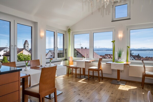 Un espace de restauration moderne doté de grandes fenêtres, de meubles en bois et offrant une vue sur la ville.