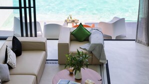 Un salon moderne comprenant un canapé, une table basse et une vue sur l’océan.