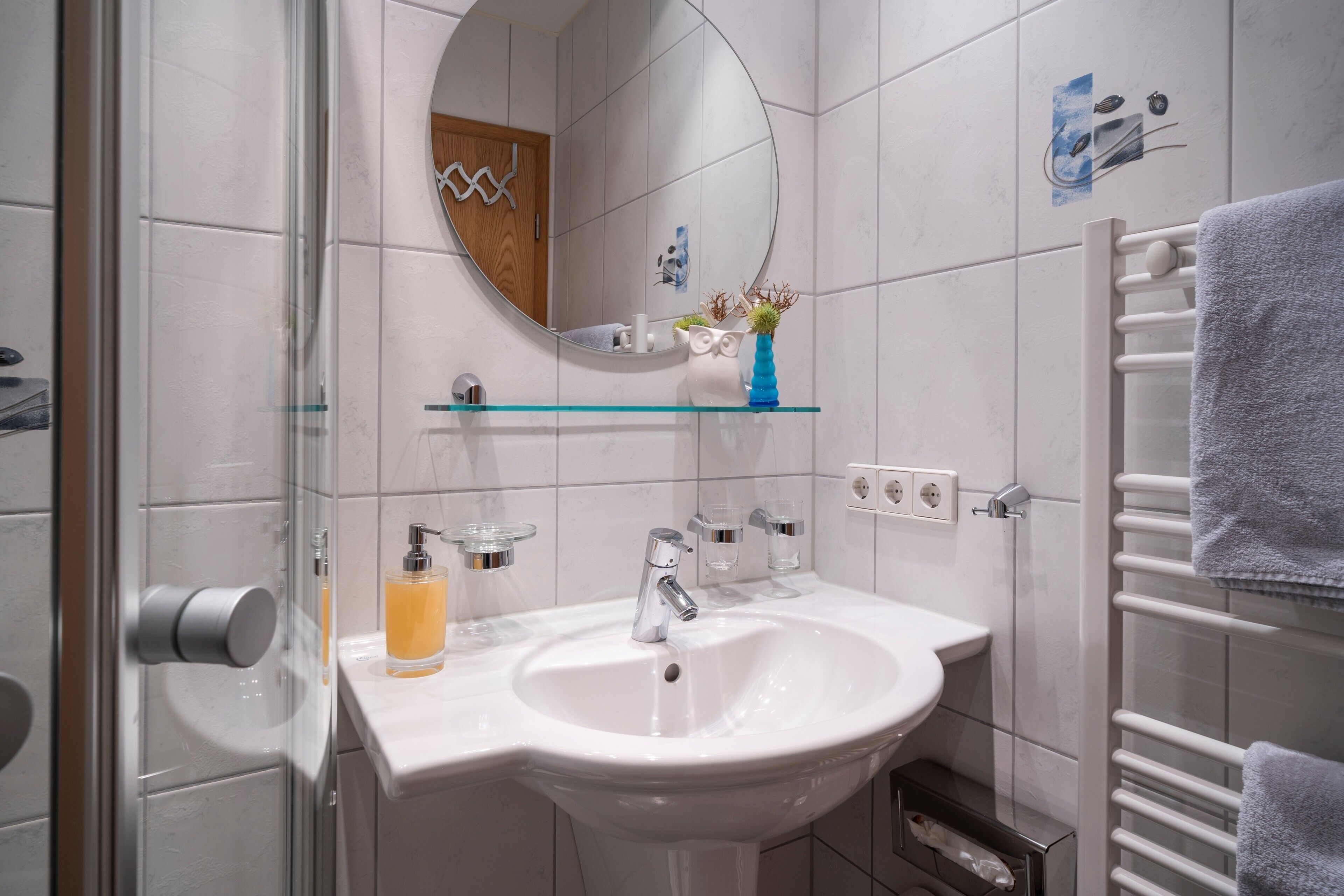 A bathroom with a white sink, mirror, and towel rack.