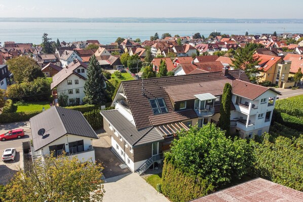 A residential area with houses, a lake, and a clear sky. - Apartment '208' with Shared Garden, Wi-Fi and Air Conditioning (Hagnau)