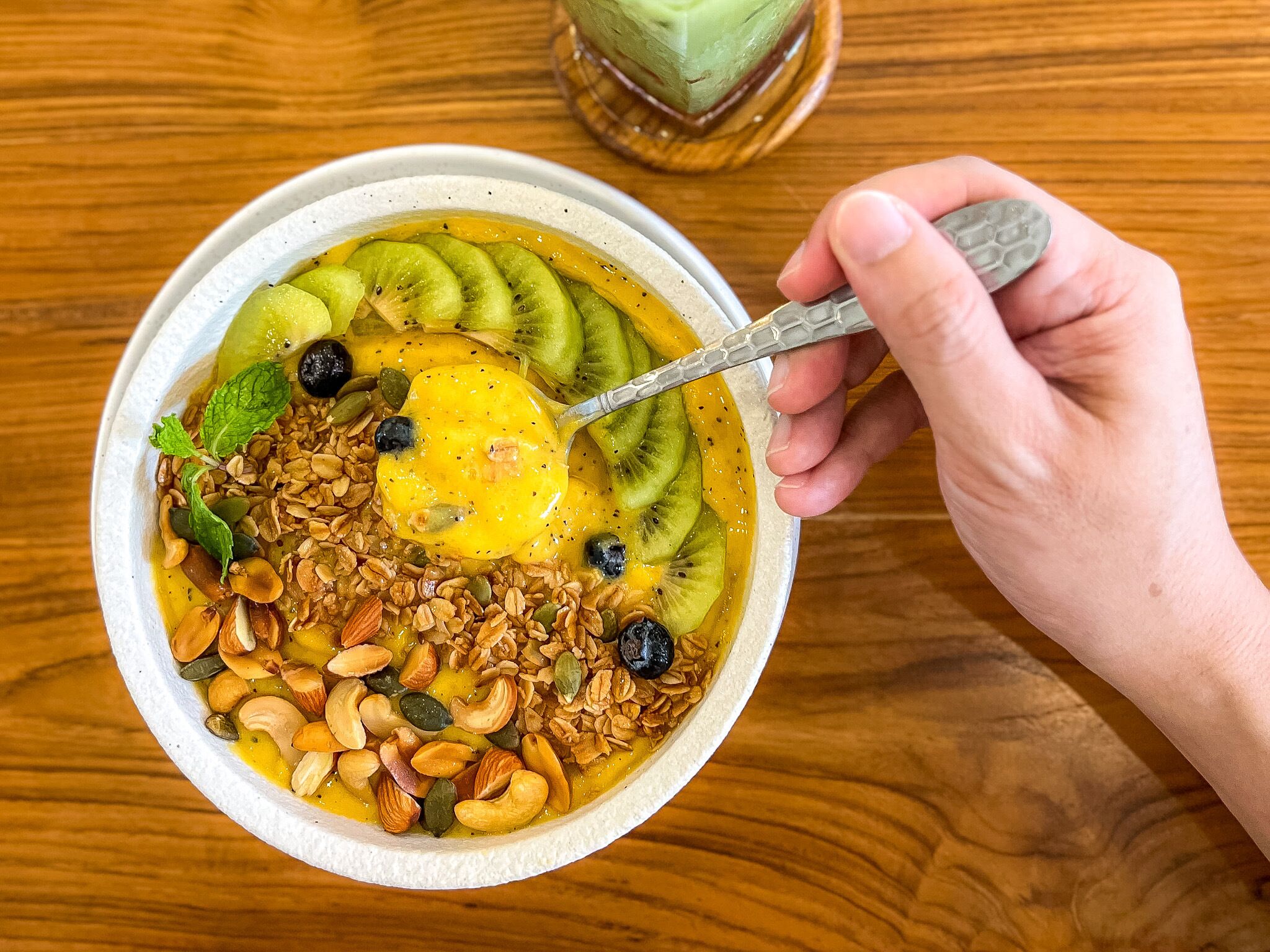 A bowl of fruit and granola with a spoon.