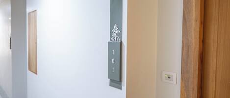 A hallway with a door labeled '101', a light switch, and a wooden door frame.