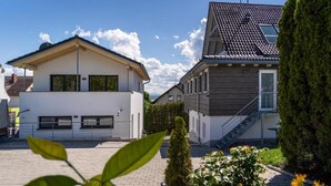 A residential area with modern houses, a paved driveway, and well-maintained greenery. - Room '102' with Shared Garden, Balcony and Wi-Fi (Hagnau)