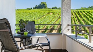 A balcony with a table and chairs, overlooking a vineyard. - Room '206' with Shared Garden, Balcony and Wi-Fi (Hagnau)