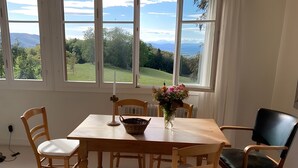 A dining area with a table, chairs, a candle, and a vase of flowers. - Apartment 1 with Alpine Views, Outdoor Seating, and Wi-Fi (Schopfheim)
