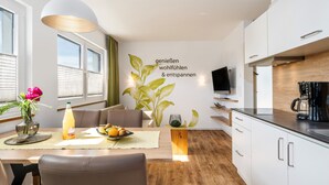 Une cuisine moderne avec des armoires blanches, un plan de travail en bois et une cuisinière intégrée.