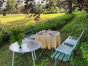 An outdoor dining area with a round table, chairs, and a bench. - Vacation home 'Maisonette 1c' with mountain view, private balcony and Wi-Fi (Schopfheim)