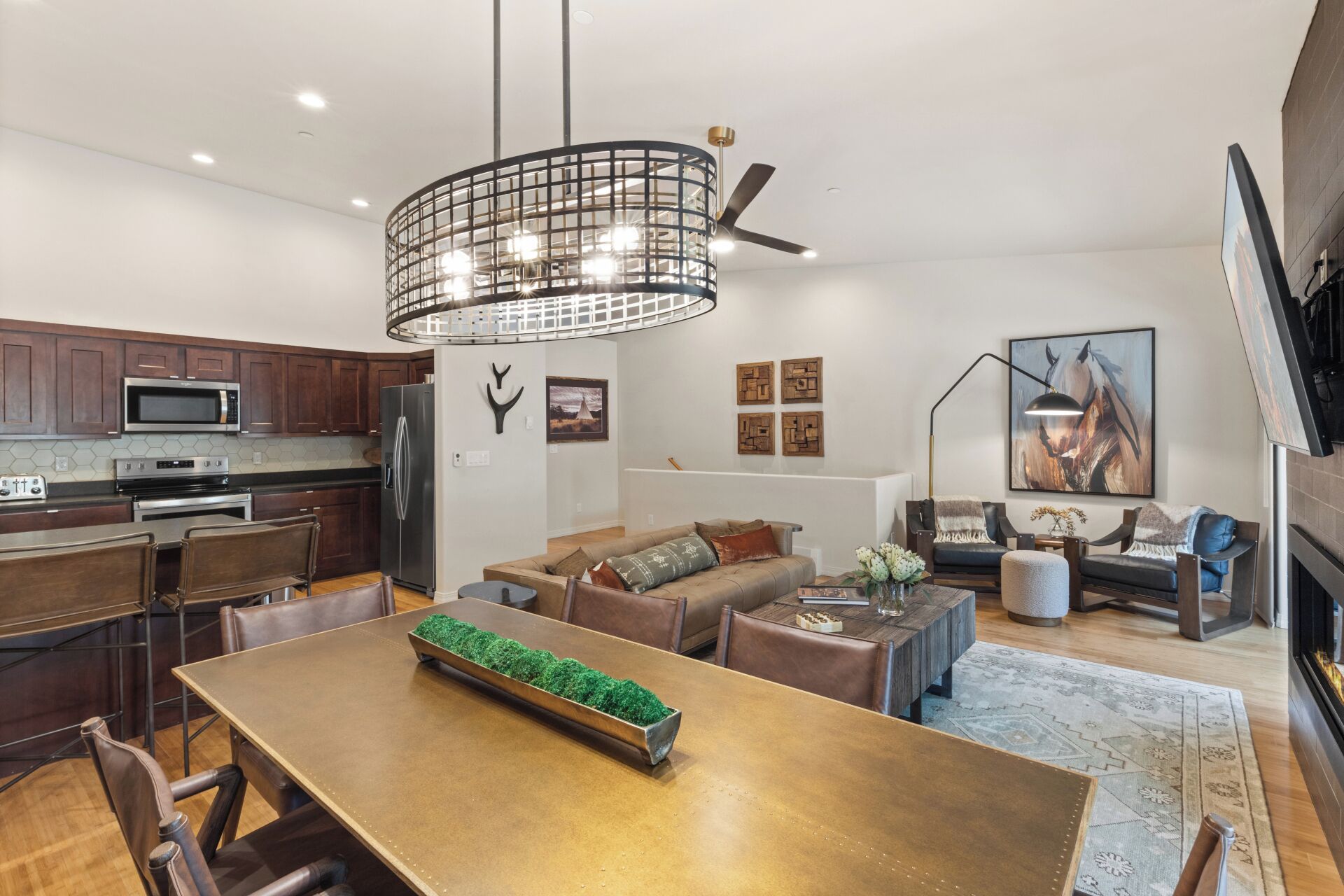 Eine moderne Küche mit Essbereich, Kamin und Wohnzimmer mit Sofa und Couchtisch.