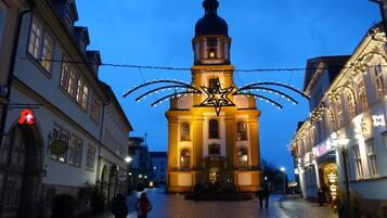 A historic building with a clock tower, a star decoration, and a cobblestone street.