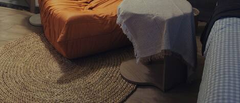 A modern room with a sofa, a small table, a lamp, and a plant.