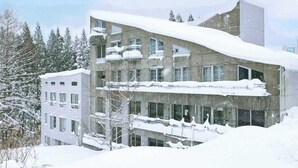 A multi-story building with a modern architectural design, featuring balconies and large windows. - HOTEL ST.MORITZ (Yuzawa)