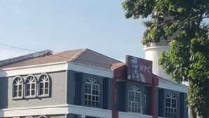 A multi-story building with a KFC sign, arched windows, and a sign that reads "HANG OUT UNTIL THE CHICKENS COME HOME." - Tambun D'Mewah homestay (Ipoh)
