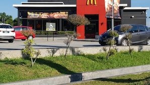 A McDonald's restaurant with a red facade, a sign for 'Property Kimi Kembali', and a disabled parking sign. - Tambun D'Mewah homestay (Ipoh)