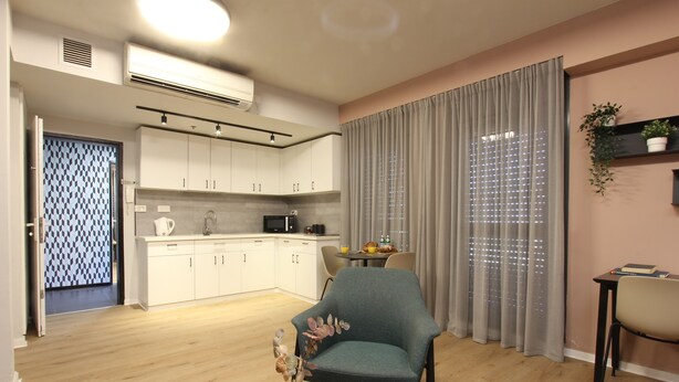 A modern living room with a dining area, kitchen, and a large window with curtains. - 1 BR Apt TLV TAU by Sea N' Rent (Tel Aviv)