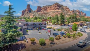 Un parking avec un bâtiment au premier plan et une chaîne de montagnes en arrière-plan.