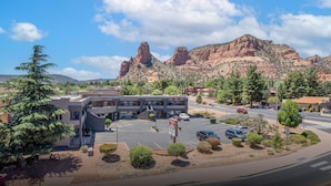 Un hotel con aparcamiento, rodeado de paisaje desértico y montañas.