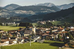 Ein Dorf mit traditionellen Häusern, einer Kirche und Bergen im Hintergrund.