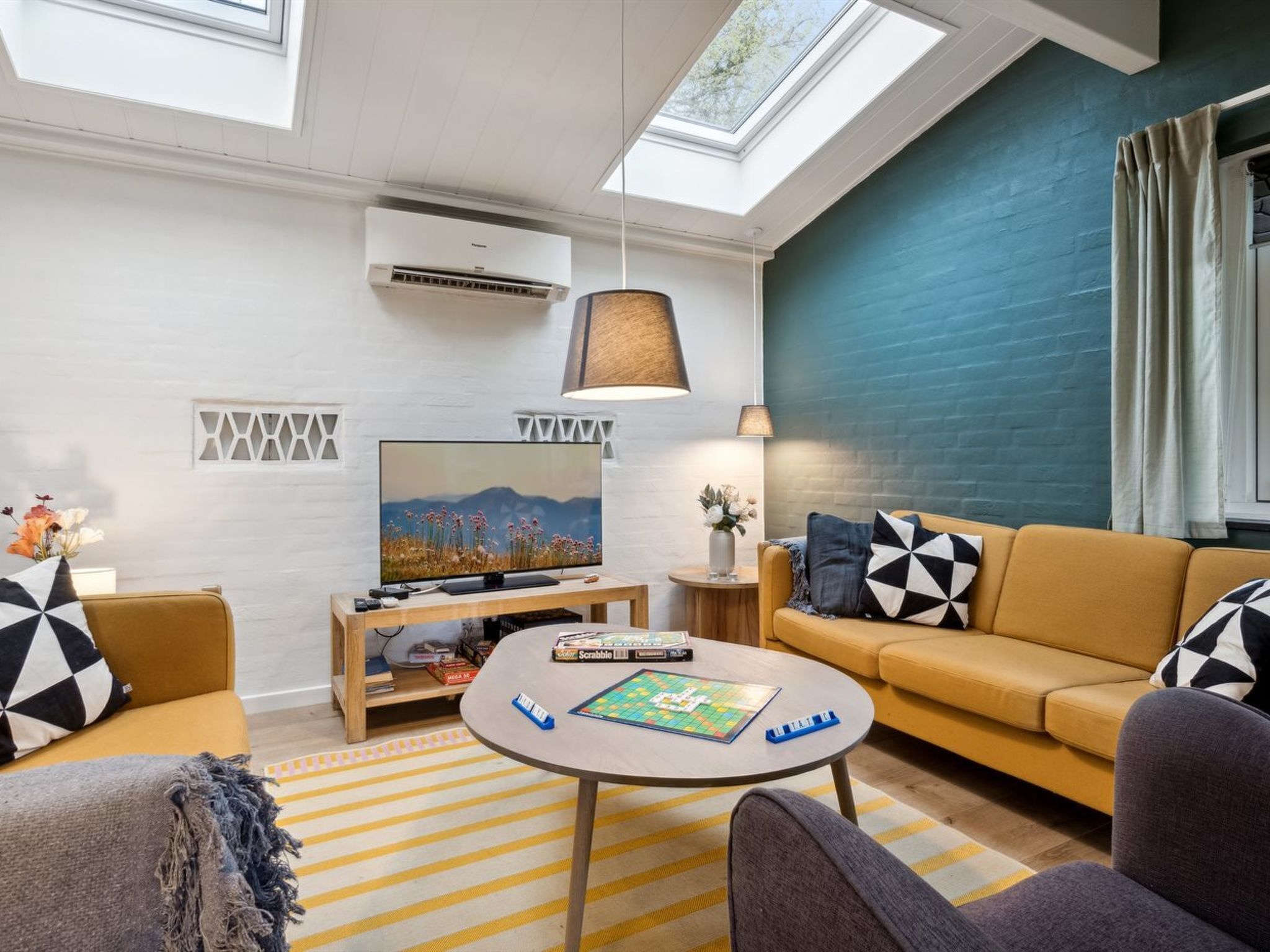 Un salon moderne comprenant un canapé, des fauteuils, une table basse et un téléviseur.