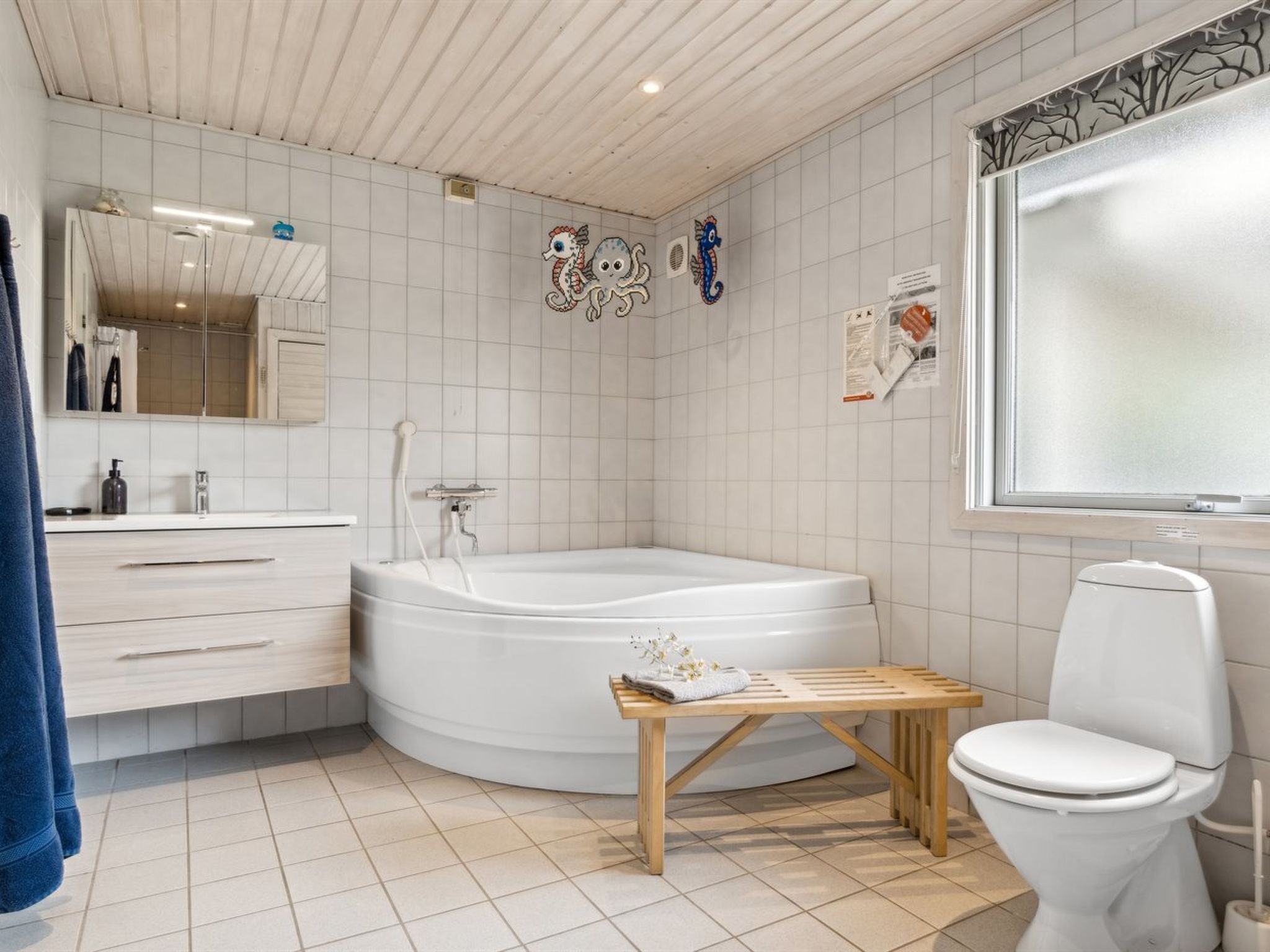 A modern bathroom with a bathtub, toilet, and vanity.