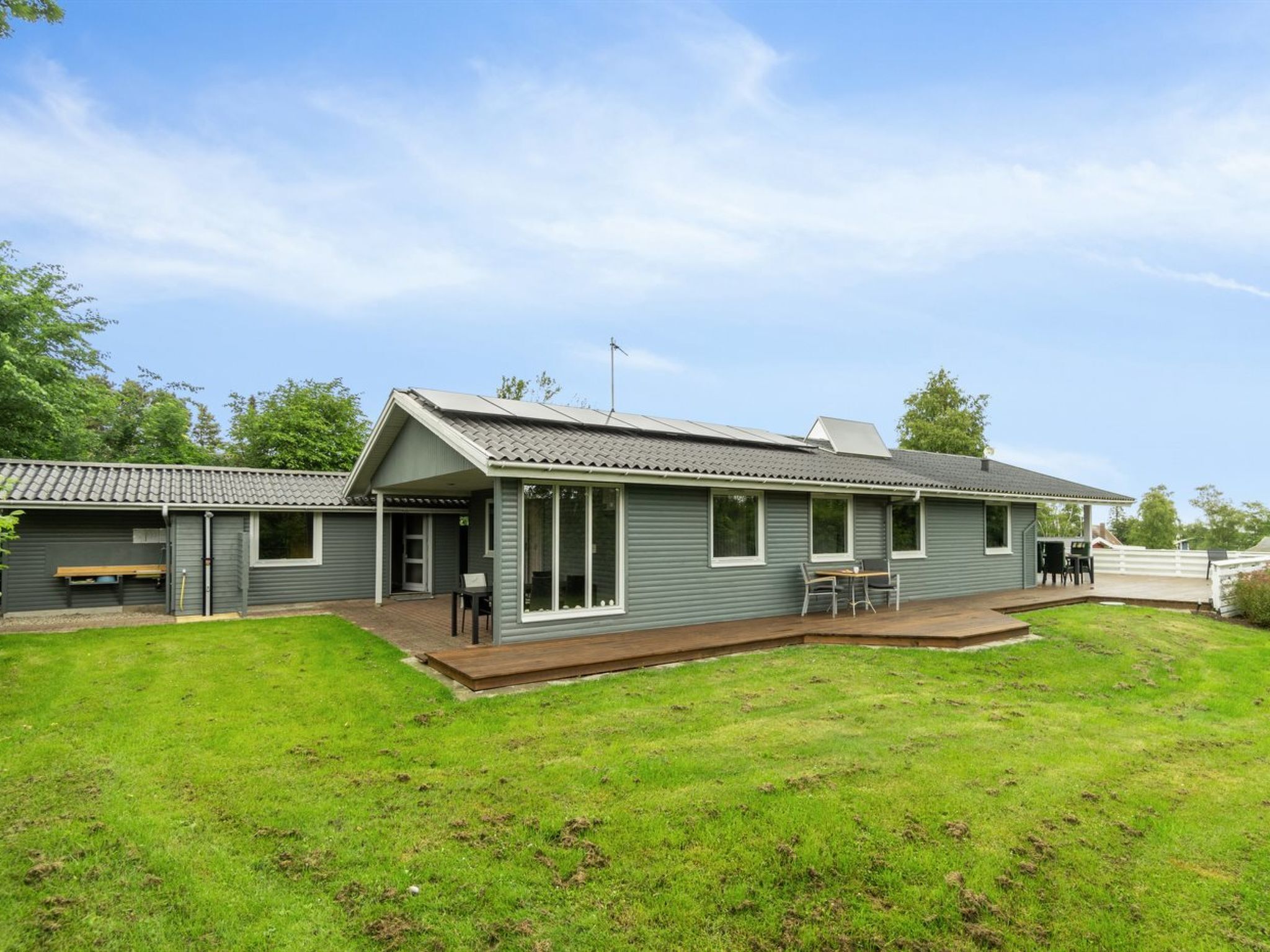 A single-story building with a covered patio area and a small lawn.