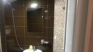 A bathroom with a pedestal sink, a shower, and a mirror on the wall. - Spacious 4-bedroom house in charming Kutaisi with WiFi, AC (Kutaisi)