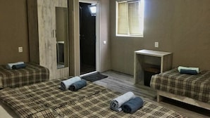 A room with two beds, a mirror, a small table, and a window with blinds. - Spacious 4-bedroom house in charming Kutaisi with WiFi, AC (Kutaisi)
