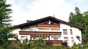 A multi-story building with balconies, a sign reading "SONNFRIED," and surrounded by greenery. - Wonderful apartment with views of the slopes (Bad Kleinkirchheim)