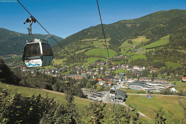 A cable car in a mountainous area with a town below.