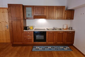 Réfrigérateur, un four, surface de cuisson, vaisselle et ustensiles