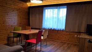 A wooden-paneled room with a dining table, chairs, and a television. - Nature & Ski Retreat in Bad Kleinkirchheim (Bad Kleinkirchheim)