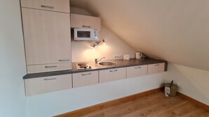 A small kitchenette with a microwave, sink, and cabinet storage. - Apartment in Bad Kleinkirchheim near hiking (Bad Kleinkirchheim)
