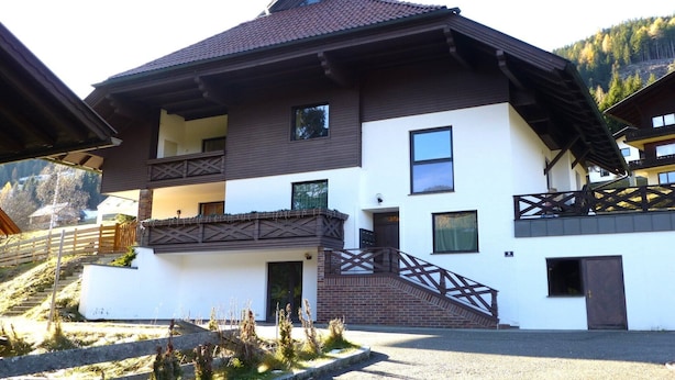 A two-story chalet with a balcony, a staircase, and a view of a mountainous landscape. - Apartment in Bad Kleinkirchheim near hiking (Bad Kleinkirchheim)
