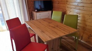 A wooden-paneled room with a wooden table and two chairs, one red and one green. - Pet-friendly apartment in Bad Kleinkirchheim (Bad Kleinkirchheim)