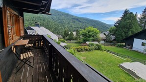 A wooden balcony with a view of a green landscape and mountains. - Apartment with mountain views (Bad Kleinkirchheim)