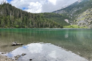 A clear lake surrounded by forested mountains.