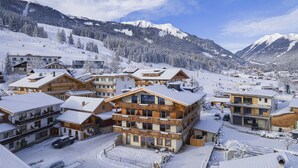 A snow-covered mountain resort with wooden buildings, ski slopes, and a clear sky. - Lavish apartment with sauna in Tyrol (Lermoos)