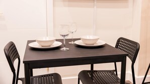 A dining table with two bowls, two wine glasses, and two plates set for two. - Modern Studio in Central London (London)