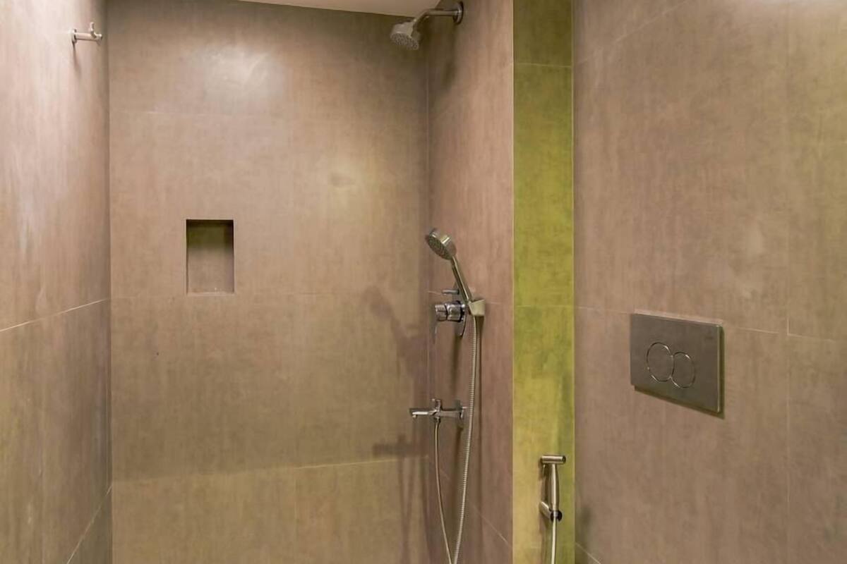 A modern bathroom with a shower, toilet, and a skylight.