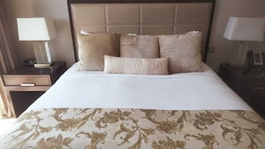 A neatly made bed with a patterned bedspread and multiple pillows. - Luxury Address Res Dubai Marina 1BR-2514 (Dubai)
