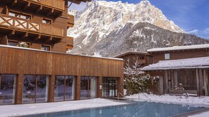 Ein modernes Gebäude mit Pool, Holzbalkonen und Bergblick.