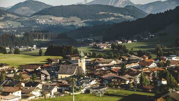 Ein Dorf mit traditionellen Häusern, einer Kirche und Bergen im Hintergrund.
