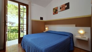 A bedroom with a large bed, a window, and a door leading to a balcony. - Wonderful house with private garden (Bibione)