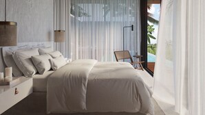 Une chambre moderne avec un grand lit, une table de chevet avec des bougies, un fauteuil près de la fenêtre et une vue sur une piscine.