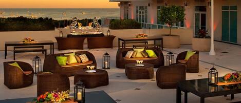 Terraza en la azotea con mobiliario exterior, zona de bar y vistas al océano.