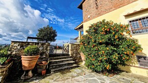 A stone staircase leading to a building with a brick facade and a large orange tree. - Bagno a Ripoli, Italy. Entire accommodation: villa (Toscana)