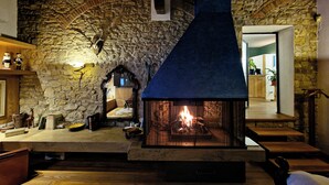 A stone fireplace with a blue chimney, a wooden ceiling, and a stone wall. - Bagno a Ripoli, Italy. Entire accommodation: villa (Toscana)